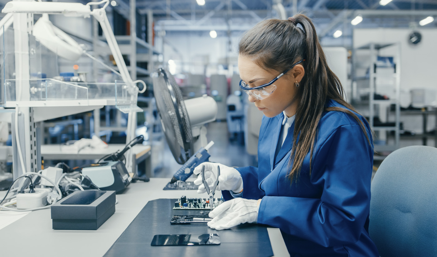 Woman using pliers at a workbench